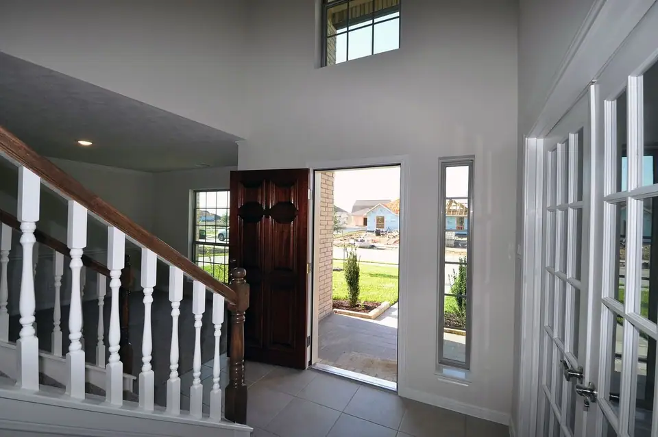 Entry foyer with staircase and glass doors at 2213 Ensenada Drive, League City, Texas