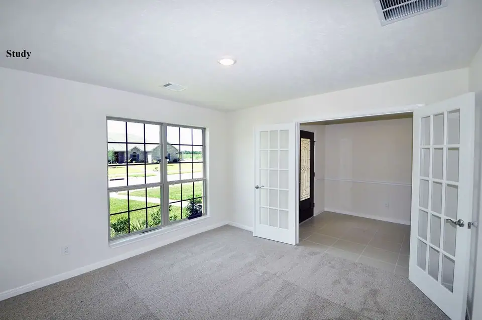 Carpeted room with glass doors and a front-facing window at 2210 Fortuna Drive, League City, Texas