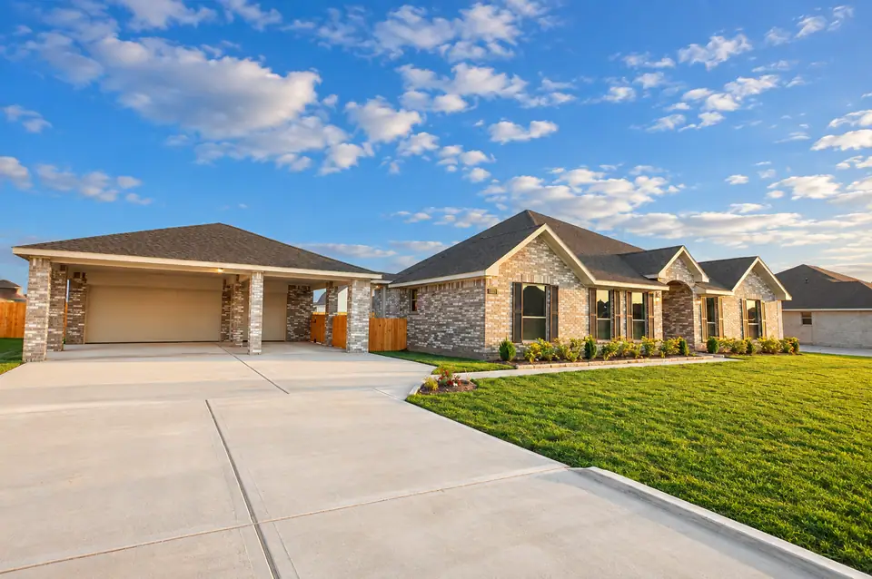Brick home with a landscaped lawn and wide covered garage