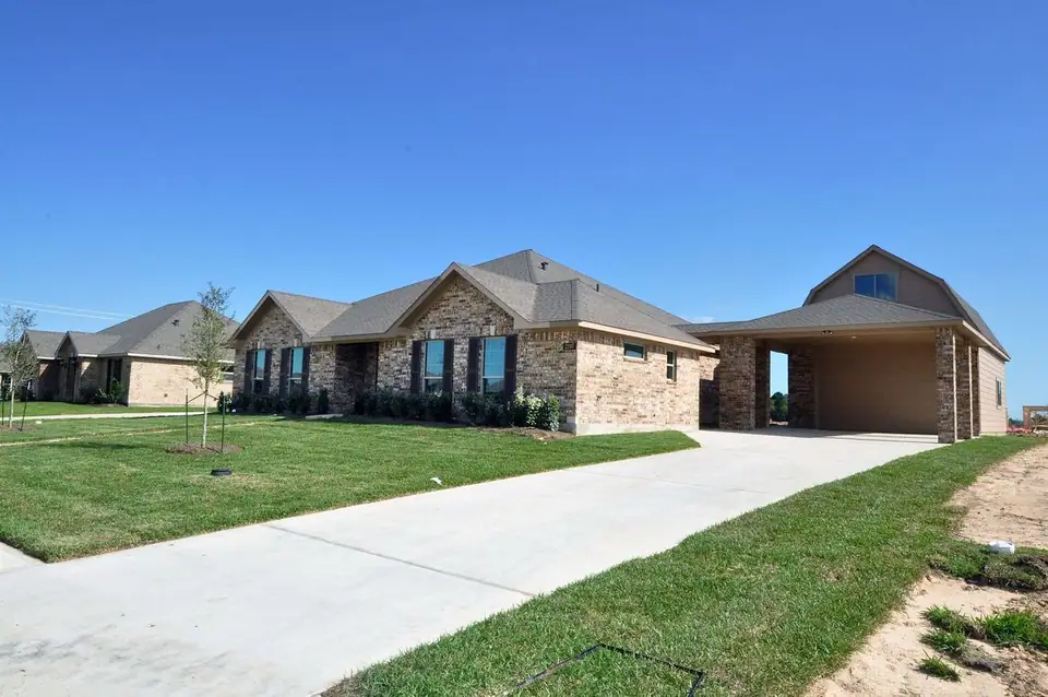 Wide driveway leading to a detached garage at 2207 Dorado Street, League City, Texas