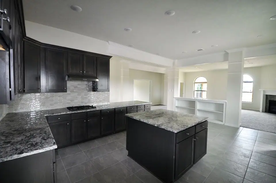 Open kitchen with a center island and dark cabinetry at 2207 Dorado Street, League City, Texas