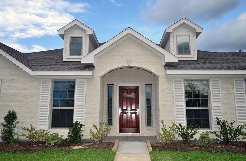 Arched front entrance with a wood door at 3821 Verde River Road, League City, Texas