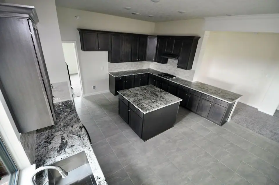 Kitchen with dark cabinets and a center island at 2207 Dorado Street, League City, Texas