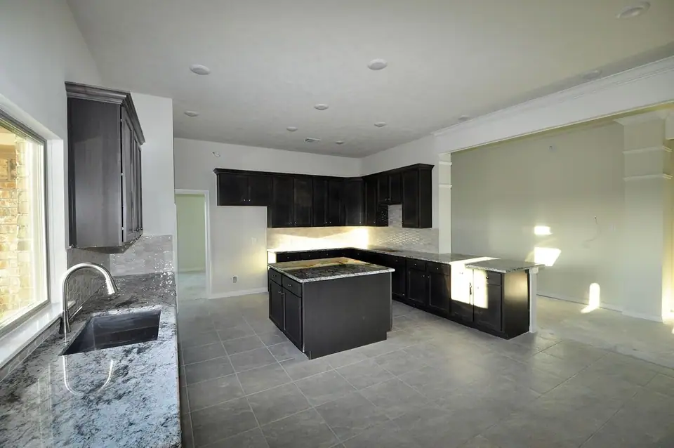 Kitchen island beside the sink and open living area at 2207 Dorado Street, League City, Texas