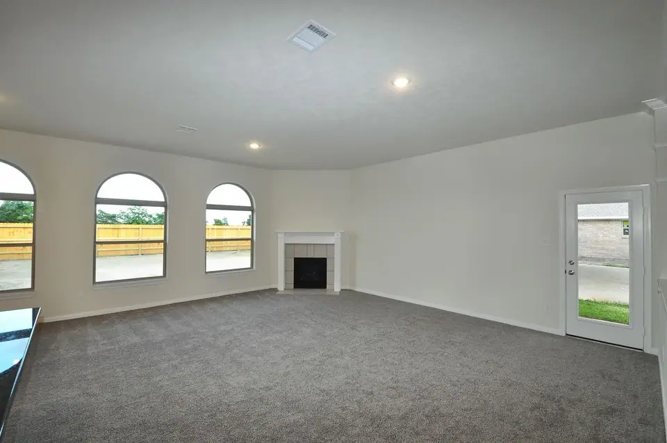 Carpeted living room with arched windows at 3821 Verde River Road, League City, Texas