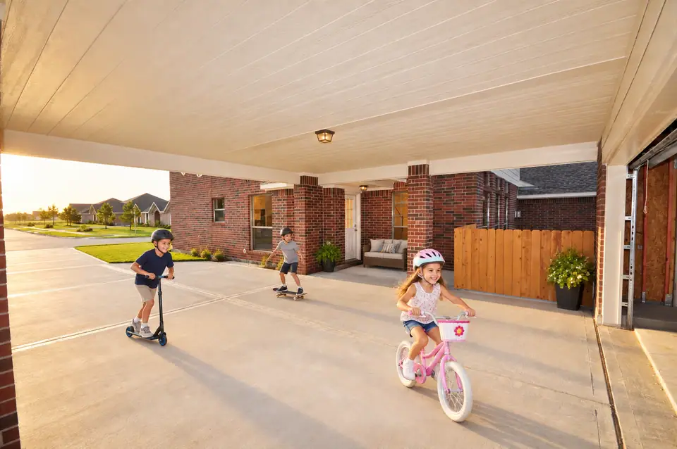 Children riding bikes and scooters beneath a covered driveway