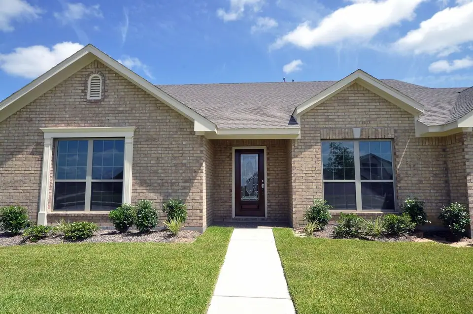 Arched front entrance and landscaped lawn at 2210 Fortuna Drive, League City, Texas