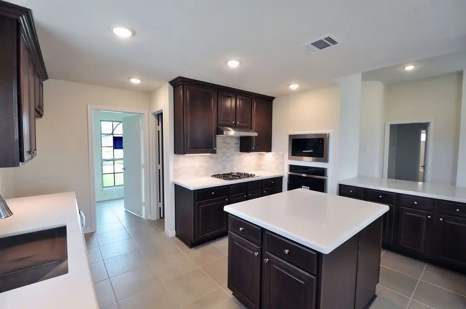 Kitchen with dark cabinets and a center island at 2206 Fortuna Drive, League City, Texas